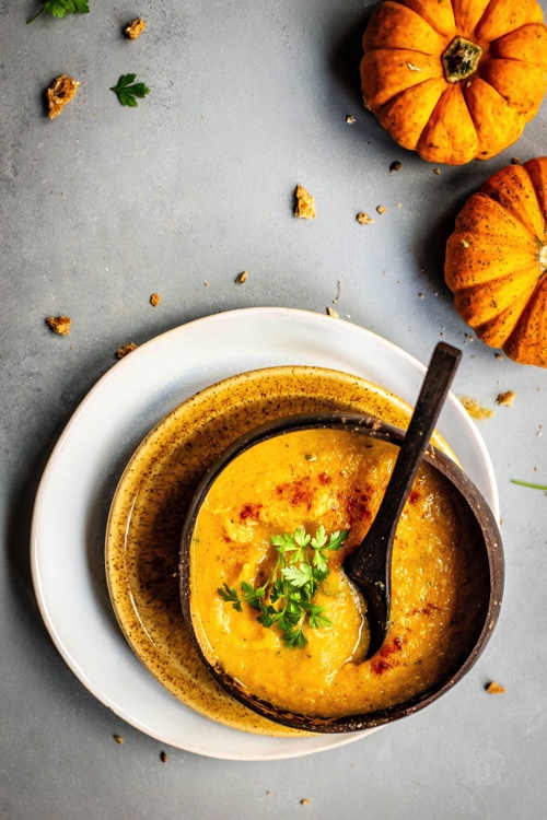 A bowl of spicy pumpkin soup, photographed from above.