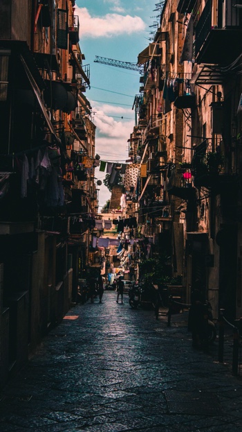 A view down a dark narrow street in Naples, Italy.